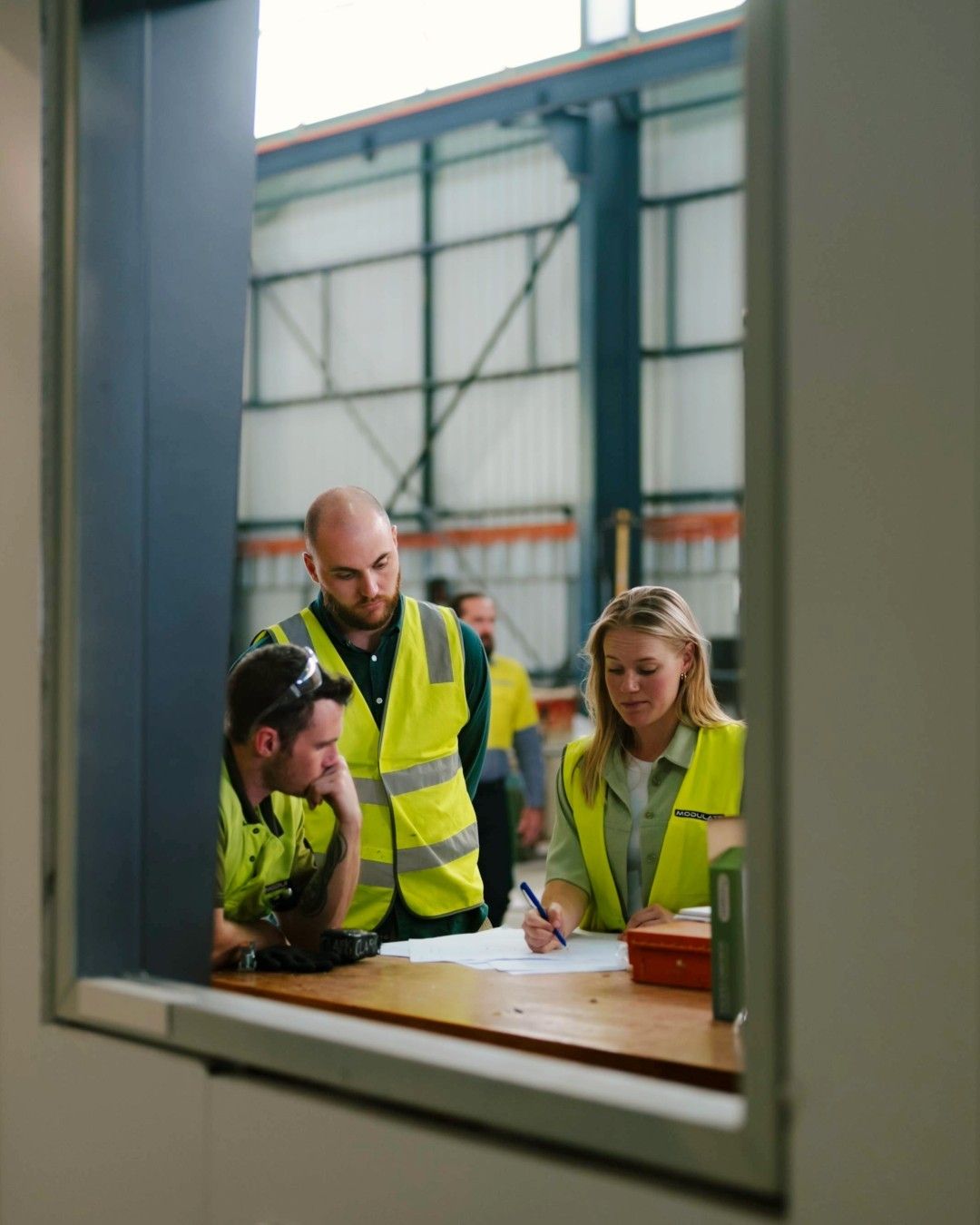 A team working through shipping documents together around a table.